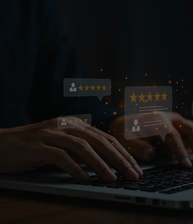 Close-up of hands typing on a laptop with glowing customer review and five-star rating interface elements on a dark background.